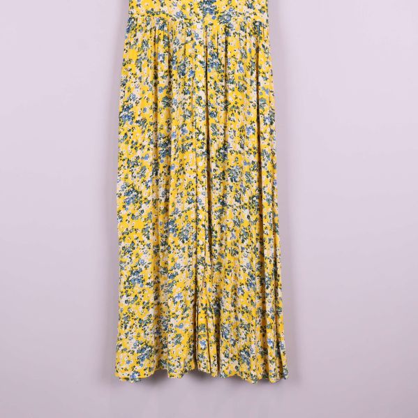 Närbild på kjolens nedre del med gulblommigt tyg