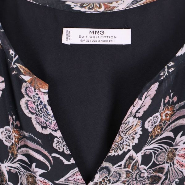 Närbild av V-ringning på blommig klänning