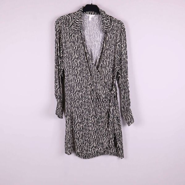 Kort omlottklänning med svartvitt grafiskt mönster och lång ärm