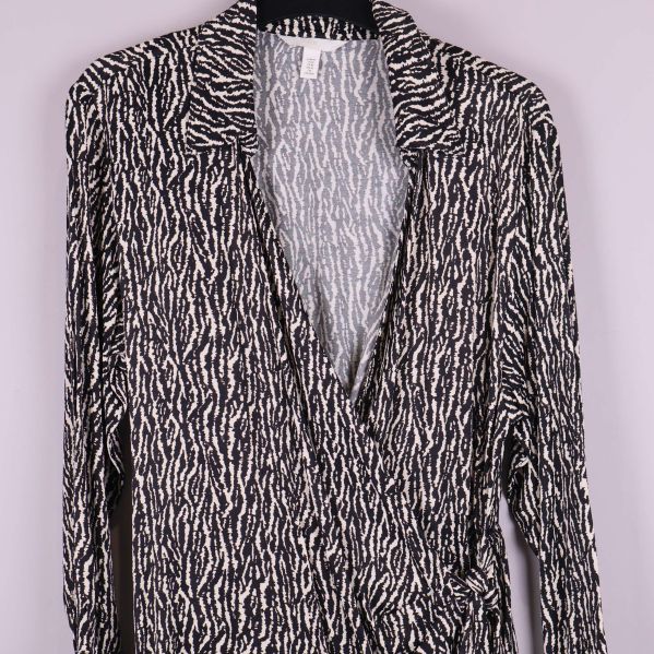 Detalj framtill på omlottklänningen med mönster och v-ringning