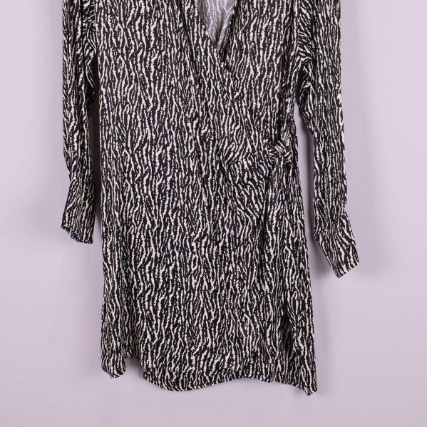 Närbild på nederdelen av omlottklänningen med svartvitt mönster