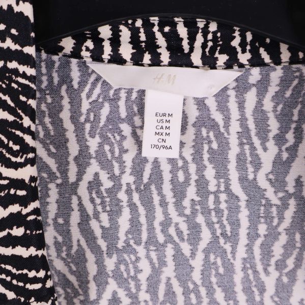 Närbild av H&M storleksetikett på klänningens insida