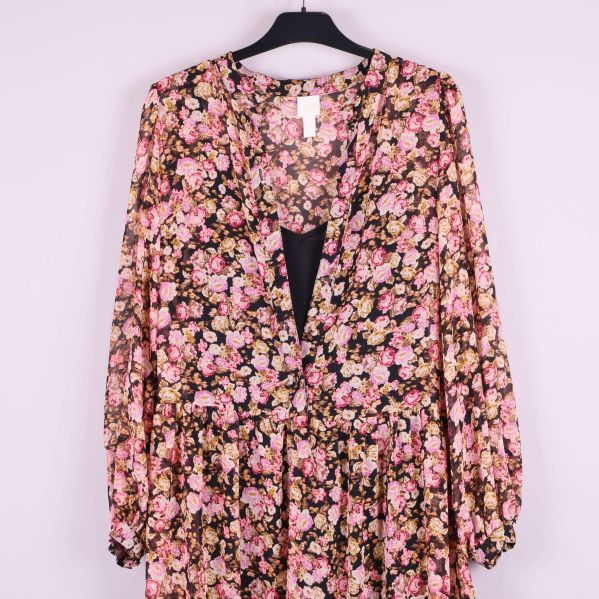 Närbild av klänningens blommiga mönster vid axlarna