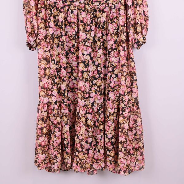 Blommiga detaljer på nedre delen av klänningen