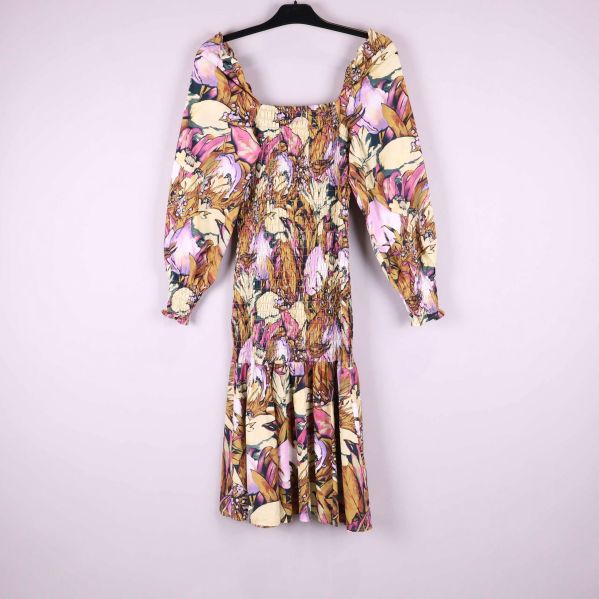 Blommig midiklänning med voluminösa ärmar fotograferad bakifrån