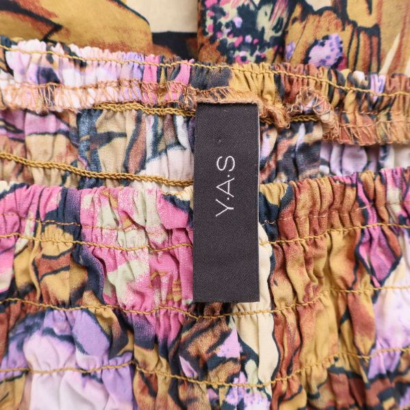 Närbild på Y.A.S-logga i klänningens linning