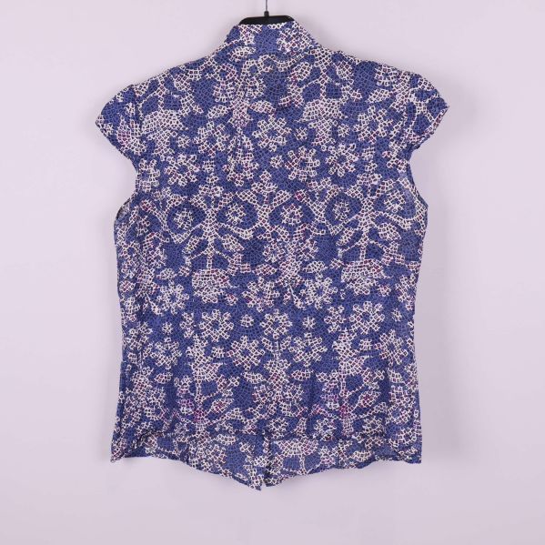 Baksida på blommig blus med volang och blåvitt mönster