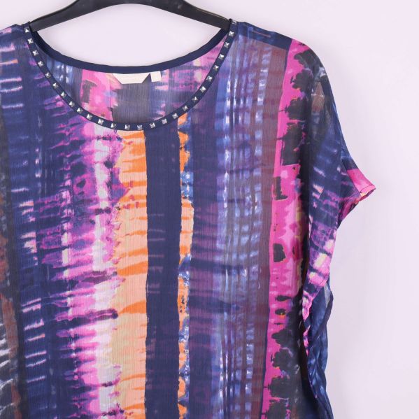 Närbild på mönster och nitar vid halsringningen på toppen