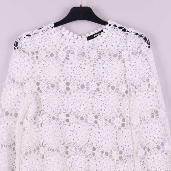 Närbild på blusens nederkant med fin spetskant