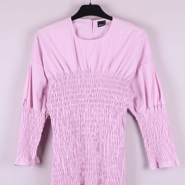 Närbild av klänningens överdel och smockade ärmar