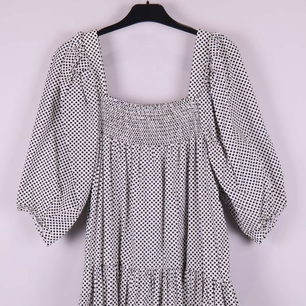 Övre delen av klänning med smock och puffärm i prickigt tyg