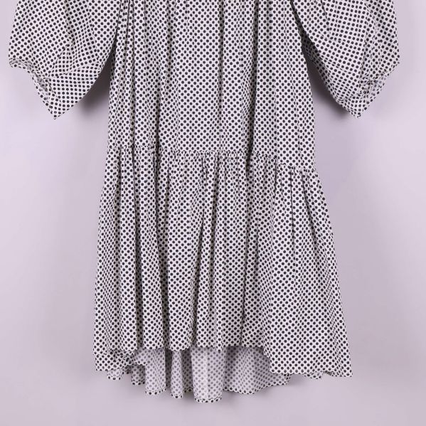 Nederdelen av en prickig klänning med volangkant