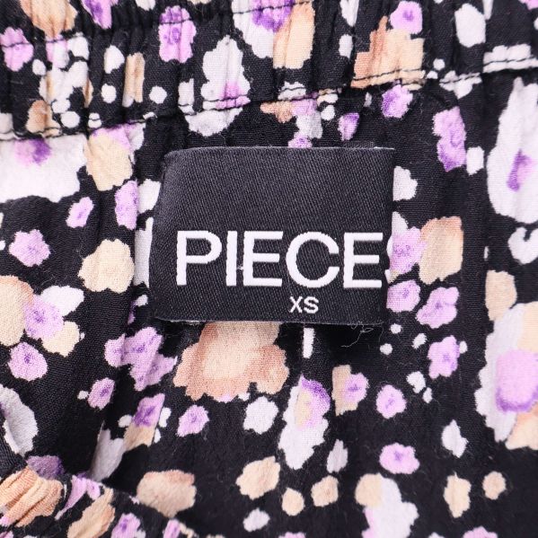 Närbild av märkning med PIECE XS på kjolen