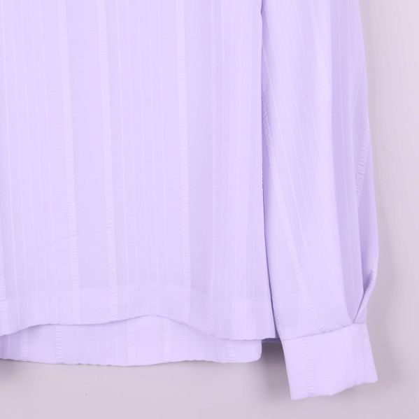 Ärmslut och nederkant på ljuslila blus med bred manschett