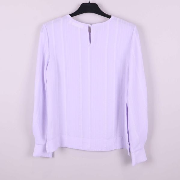 Baksida av ljuslila långärmad blus med knapp vid nacken