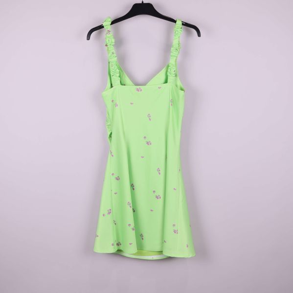 Baksidan av ljusgrön klänning med lila blommor och rynkade axelband