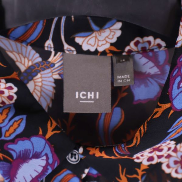 Närbild på ICHI-märkeslapp och blommigt tyg