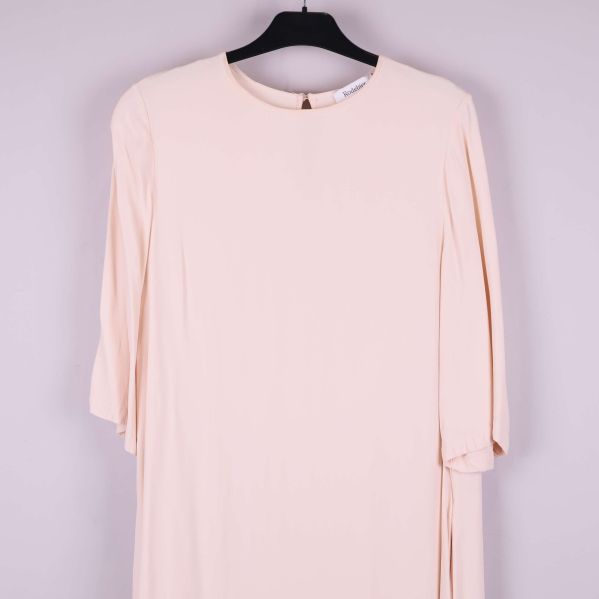 Närbild på rund hals och trekvartsärm på klänning