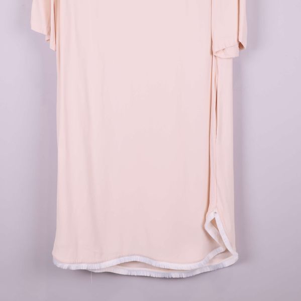 Närbild på fransdetaljer vid klänningens nederkant