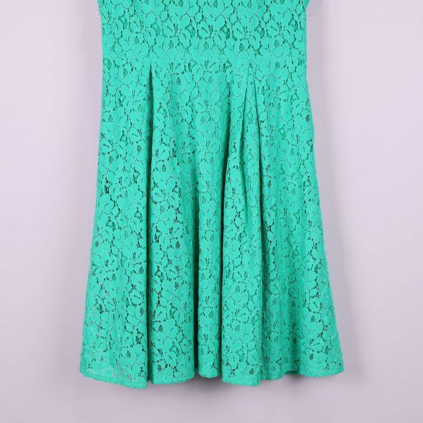 Detalj av kjolens nedre del med veck och spetsmönster