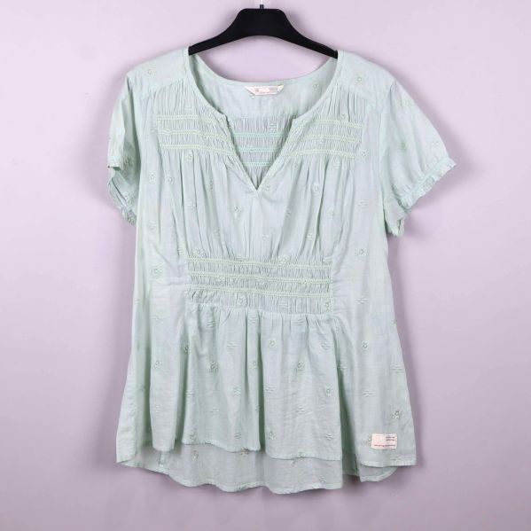 Ljusgrön blus med broderade detaljer och v-ringning på galge