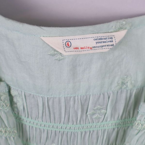 Närbild på Odd Molly-etikett i nacken på blusen