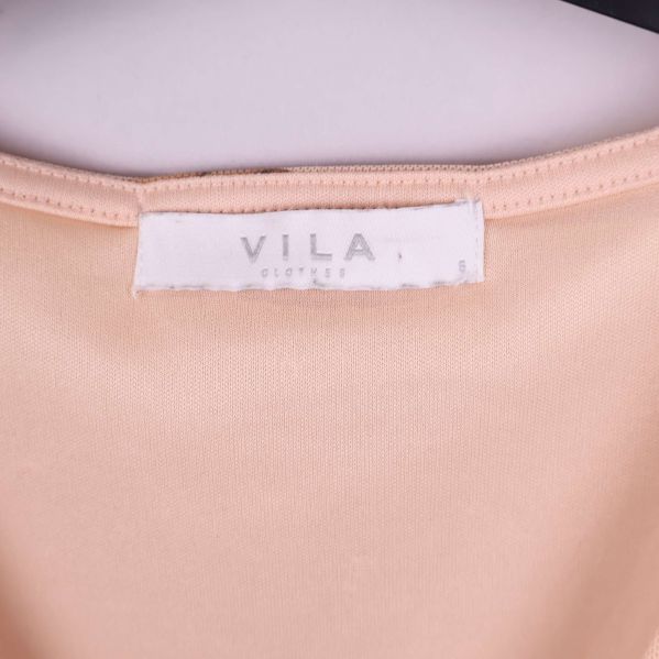 Närbild på ljus märkesetikett med VILA-text