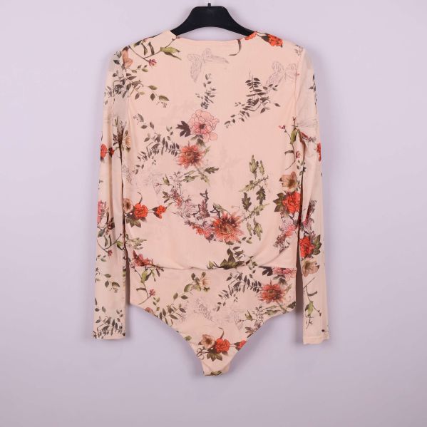 Baksidan av blommig beige body med ärm