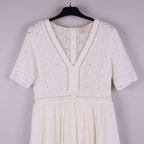 Närbild på broderad V-ringning och ärmar framtill