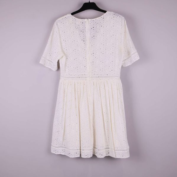 Klänning bakifrån visar dold dragkedja och broderade mönster i tyget