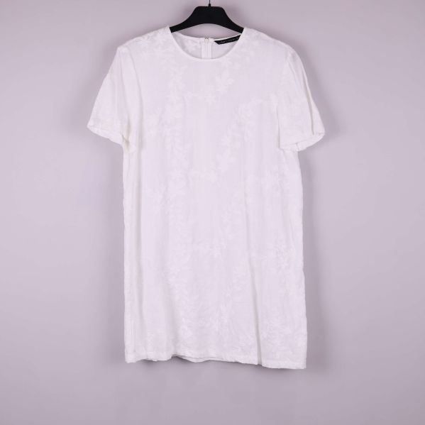 Kortärmad vit klänning med strukturmönster på galge