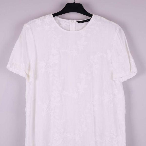 Detaljbild på klänningens framsida och ärm