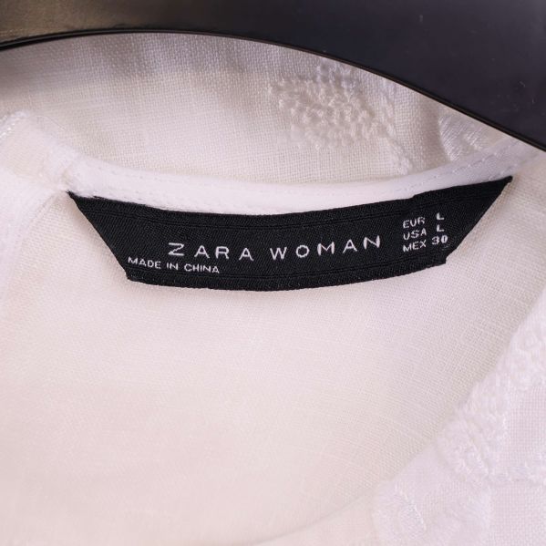 Närbild på svart ZARA WOMAN-etikett i klänningen