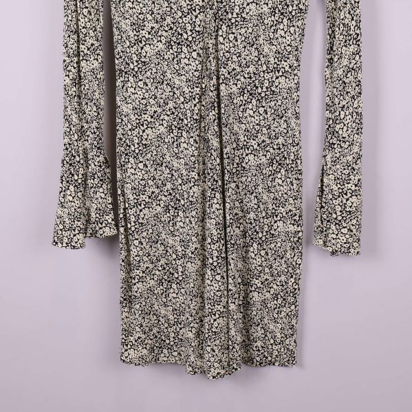 Nedre del av blommönstrad klänning i beige och svart