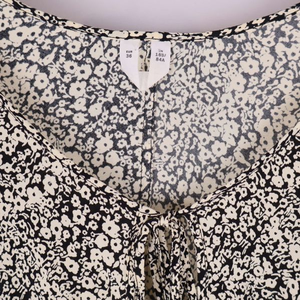 Närbild på blommönstrad klänning och storleksetikett