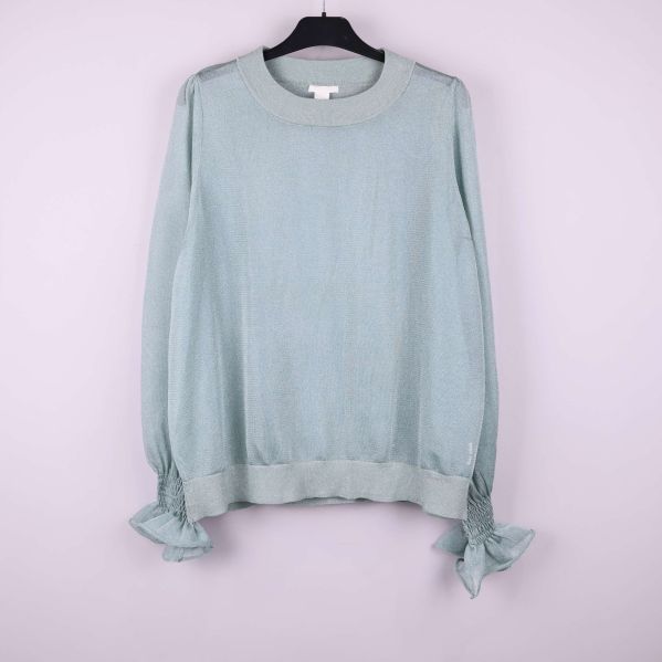 Ljusgrön tröja med ribbad krage och volangärmar framifrån