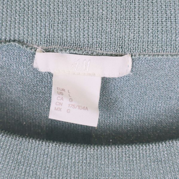 Närbild på storleksetikett från H&M i tröjans hals