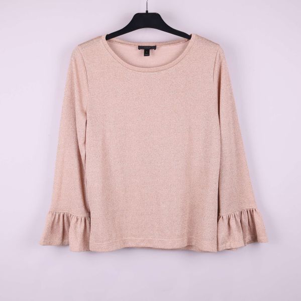 Beige tröja med volangärm och rund hals hänger på galge