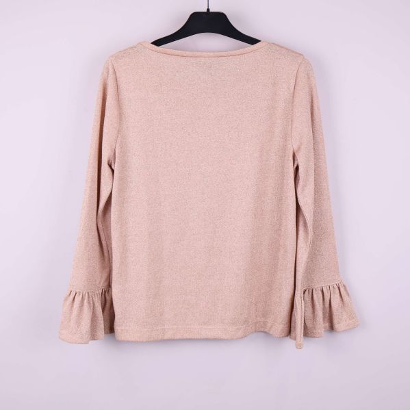 Baksida av beige tröja med volang vid ärmslut