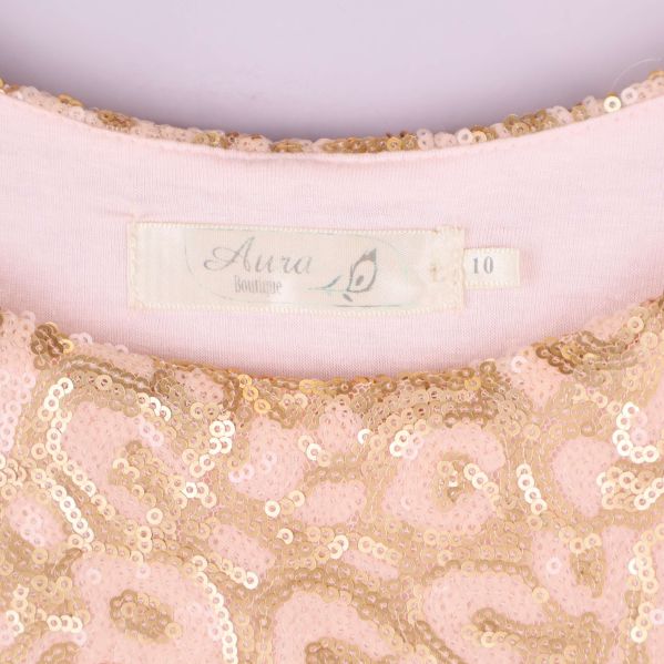 Närbild på etikett, text Aura Boutique och storlek 10