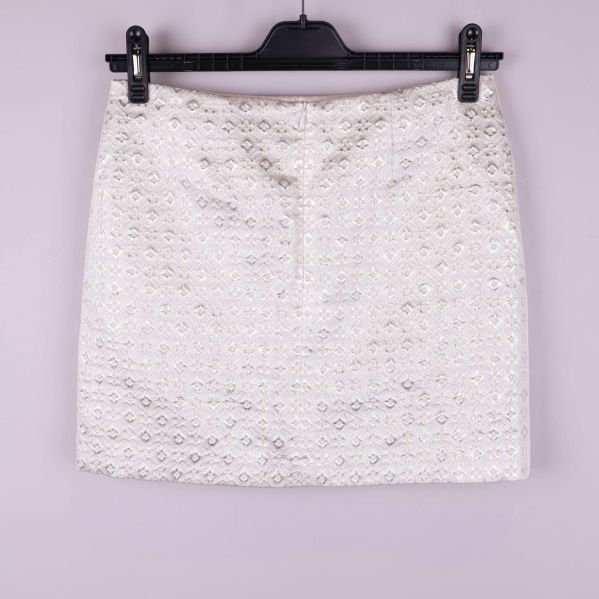 Kort kjol i ljust tyg med strukturmönster bakifrån