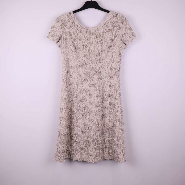 Kortärmad beige klänning med strukturerat blommönster på galge