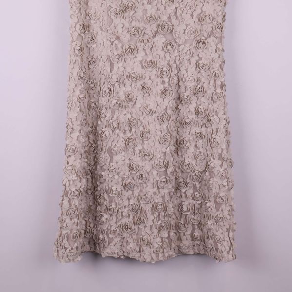 Nederdelen av klänningen med strukturerade blommor i fokus