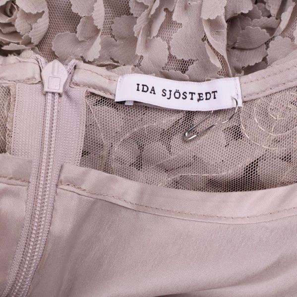 Närbild på etikett som visar varumärket Ida Sjöstedt och dragkedja