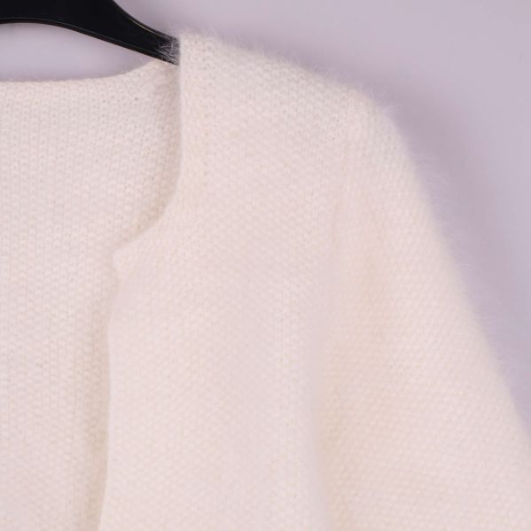 Närbild av koftans stickade material och öppen front