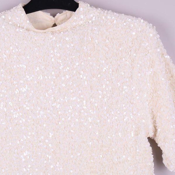 Närbild på glittrande paljettdetaljer på toppen