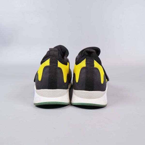 Baksidan av sneakers med gul och svart design