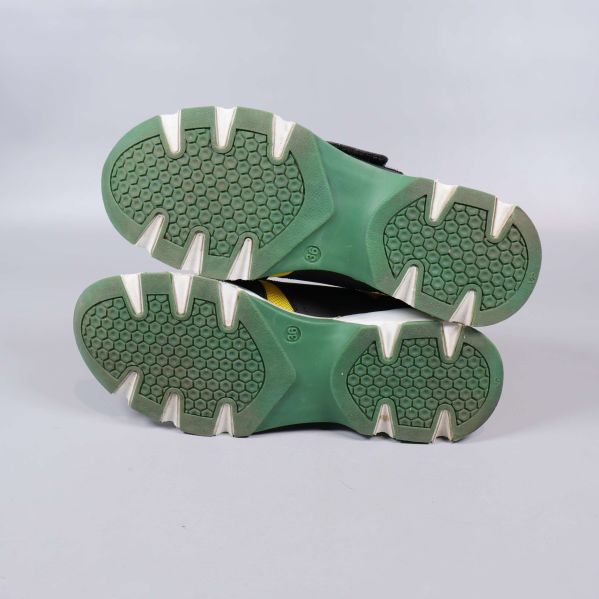 Undersida av sneakers med grön sula och mönster