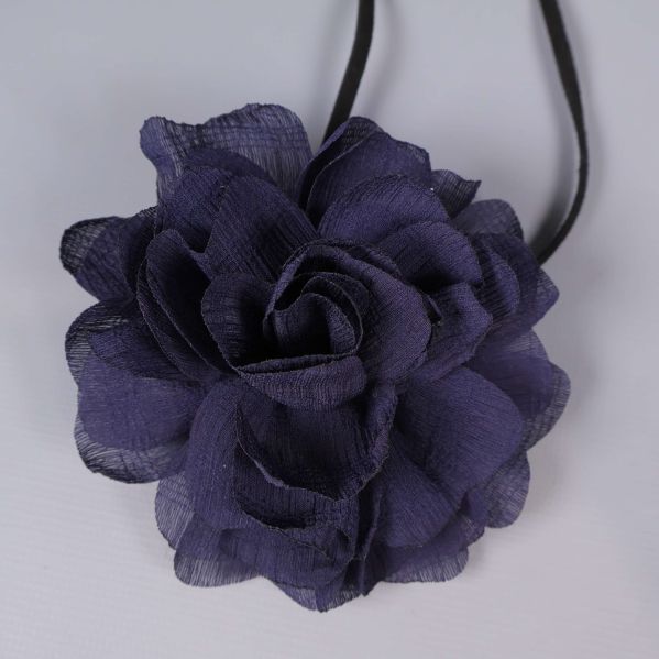 Närbild på lila tygblomma med veckade kronblad