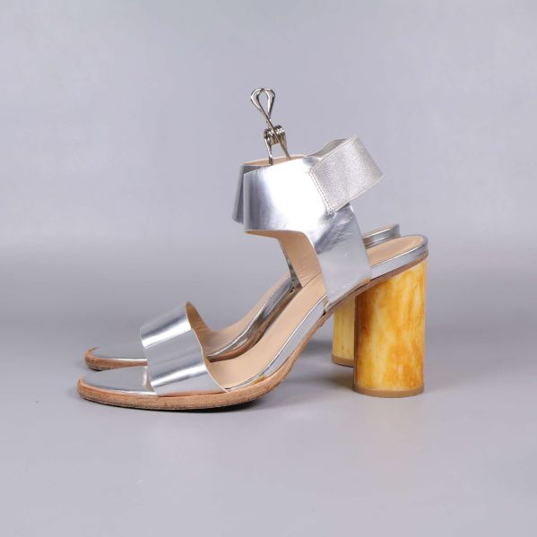 Profilbild på sandaler med silverband och hög gul klack